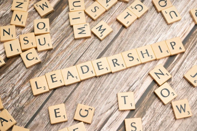 scrabble tiles spelling out the word leadership on a wooden surface